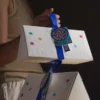 Triangular magnetic flip-top gift box with ribbon handle and embossed text, custom premium packaging